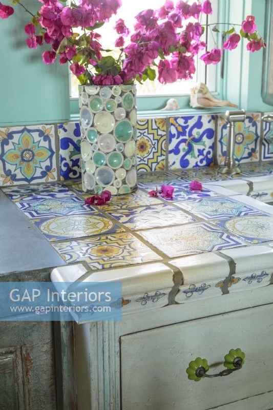 Cream-colored ceramic tiles edge a patchwork of hand painted Mexican tiles.