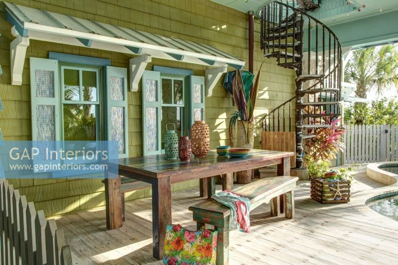 A  wood awning and decorative shutters give the pool deck a Caribbean flavor.