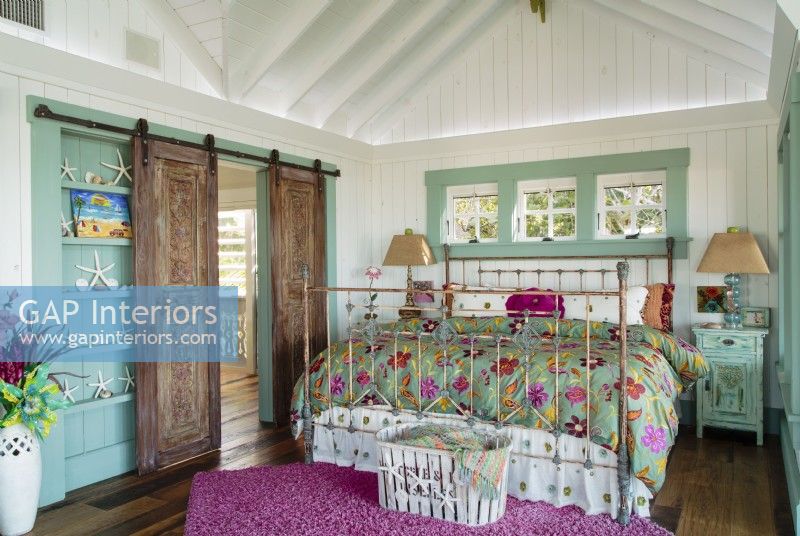 The master bedroom features vintage shutters converted into a sliding door using classic barn hardware.