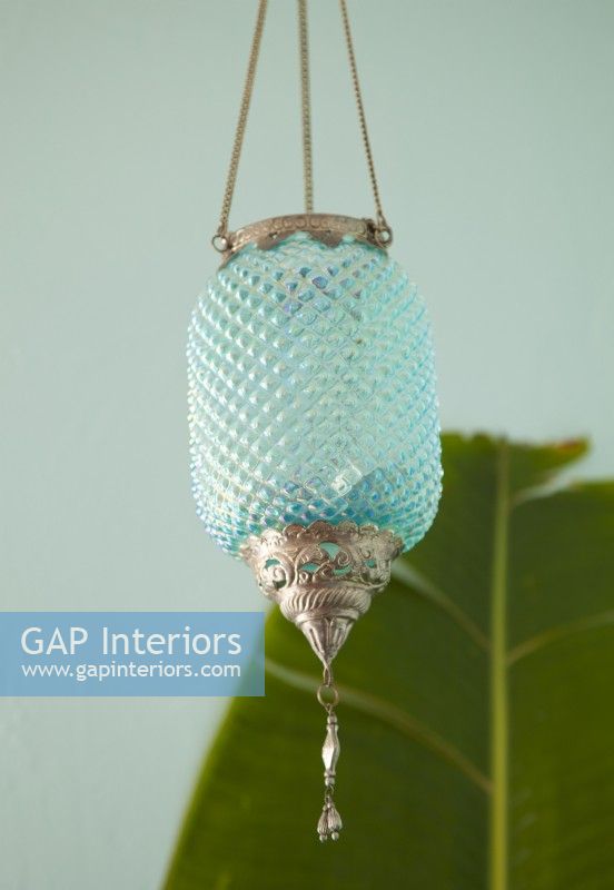 A cut-glass aqua lantern adds a touch of intrigue and complements the color scheme.