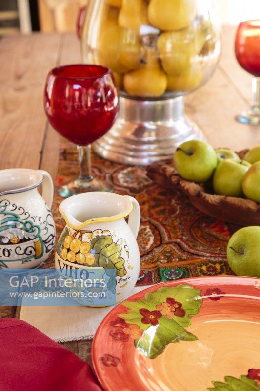 Handcrafted Italian pitchers and plates share the limelight with ruby red glasses.  