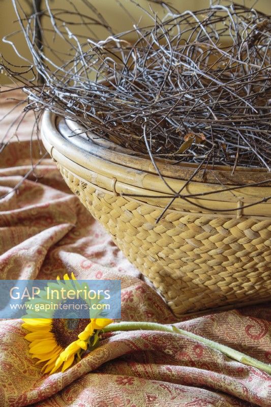 A tangle of grapevine clippings gathered in a braided basket create an organic centerpiece.