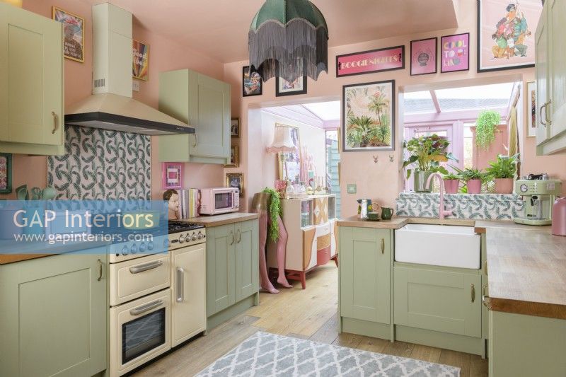 Pale pink and green Shaker retro style kitchen with cream coloured cooker