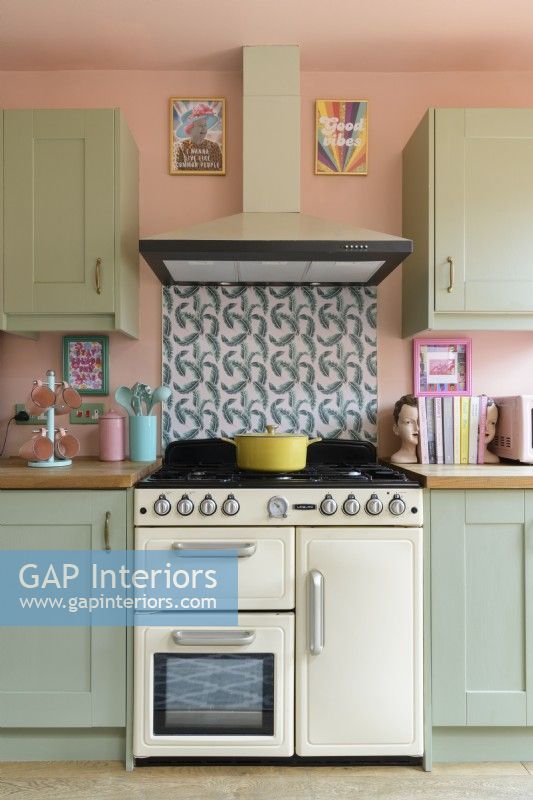 Cream coloured cooker in a Shaker style retro kitchen with a patterned tiled splashback