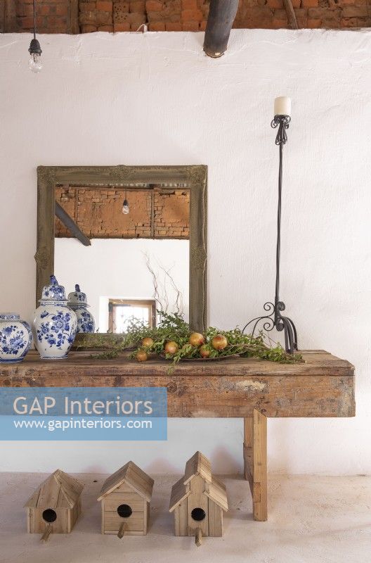 Mirror, ceramics, fruit and candle holder on old workshop table