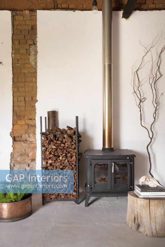 Woodburning fireplace in front of exposed brick wall