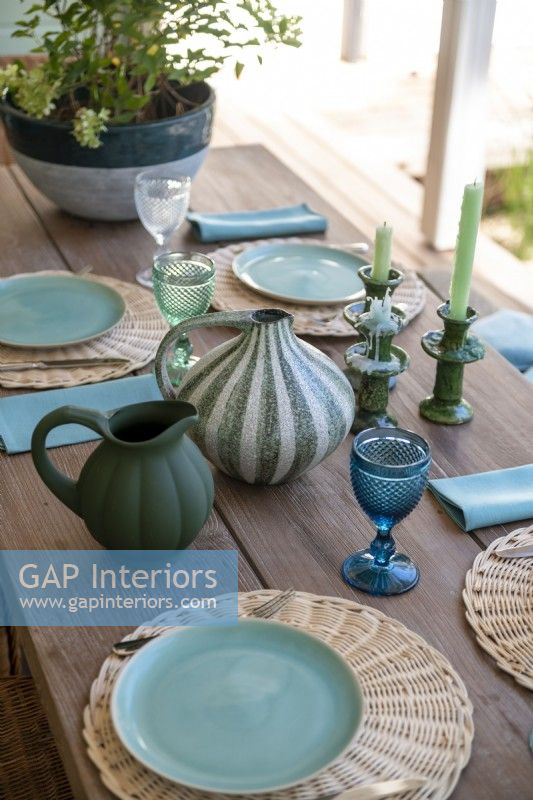Blue and green crockery on wooden outdoor dining table - detail