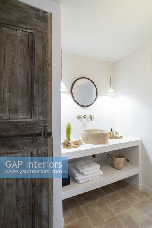 Stripped wooden door in country bathroom with built-in sink unit