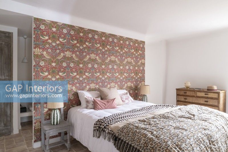 Country bedroom with patterned wallpapered feature wall