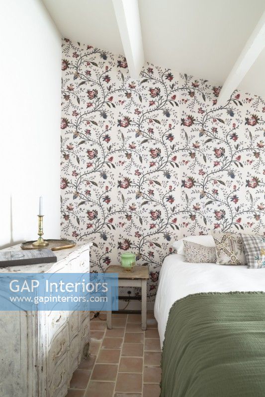 Country bedroom with floral wallpapered feature wall