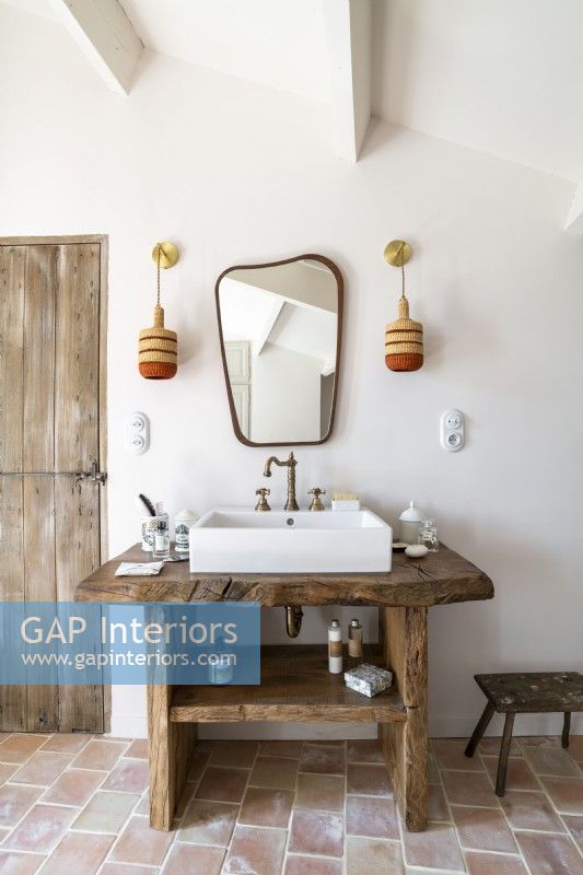 Rustic wooden sink unit in country bathroom 
