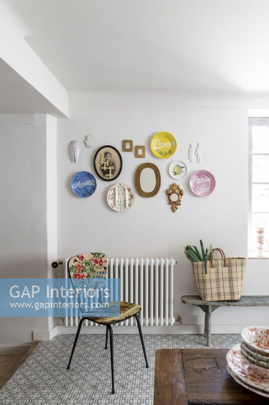 Display of eclectic and vintage plates on wall of dining room