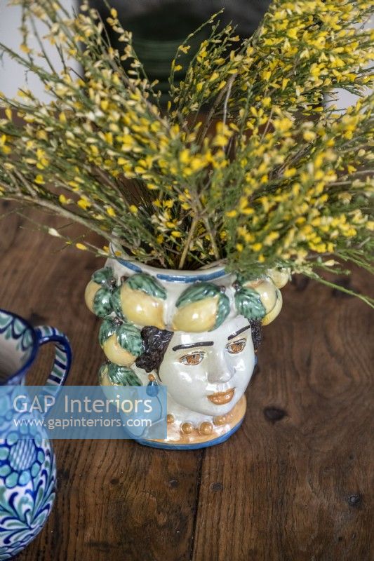 Detail of painted ceramic vase with yellow flowers