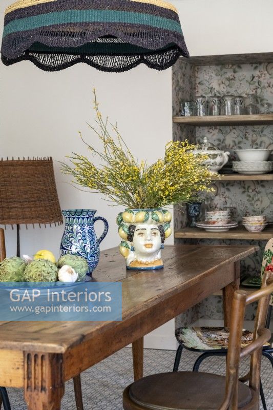 Decorative painted ceramic vase on wooden country dining table