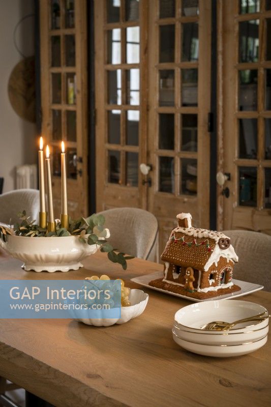 Gingerbread biscuit house on dining table at Christmas