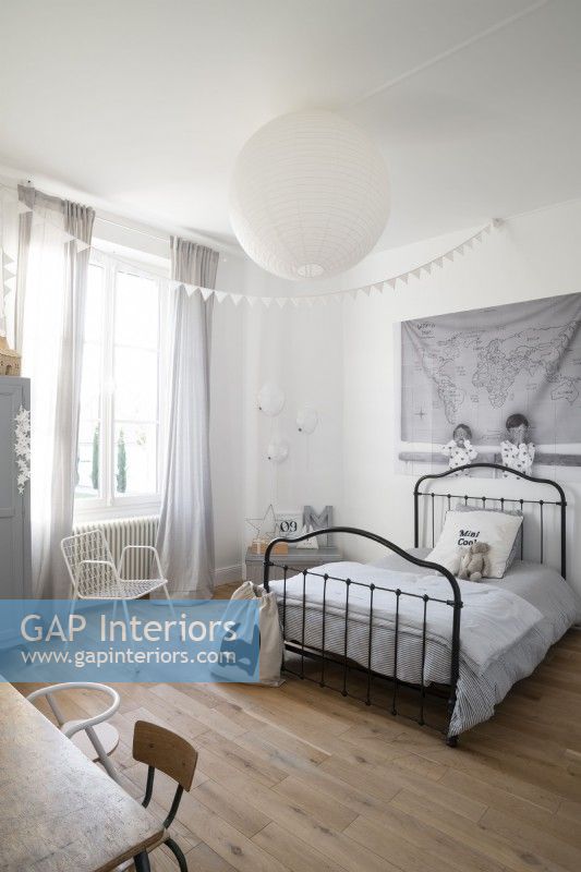 Black iron bedstead in white childrens bedroom