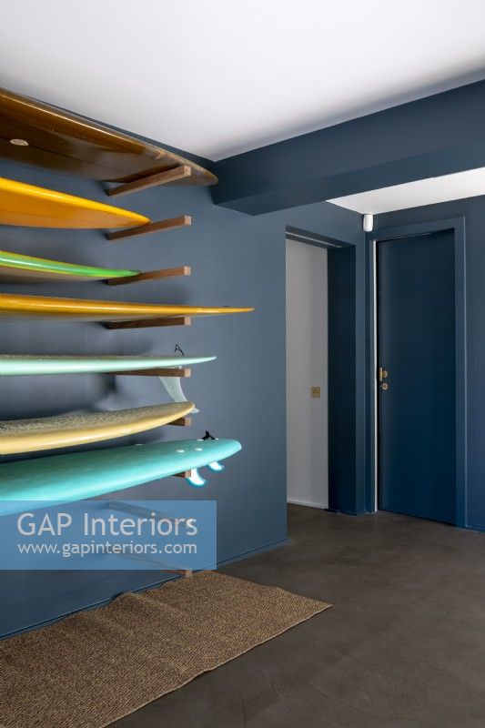 Dark grey painted modern hallway with surfboard storage rack
