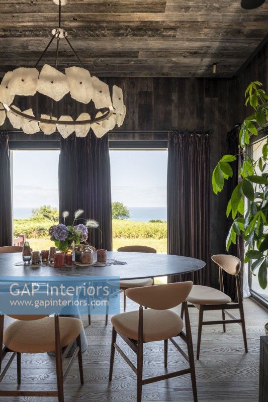 Chandelier over large round dining table with sea views