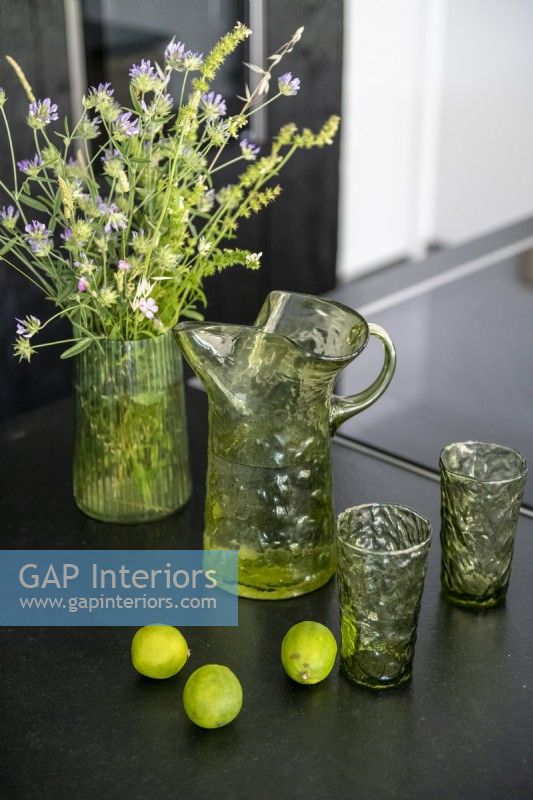 Glassware and flowers on black kitchen worktop