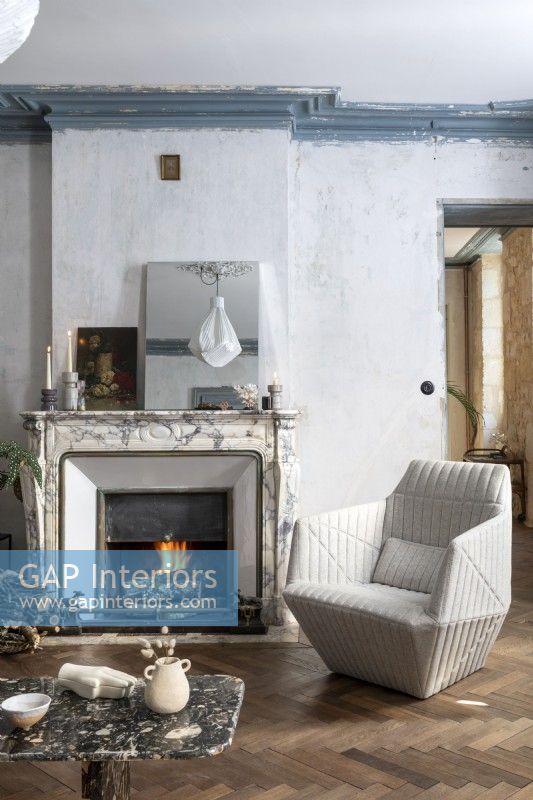 Modern armchair in country living room with lit fire