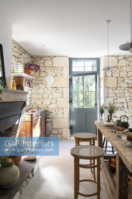 Barstools and fireplace in rustic country kitchen-diner 