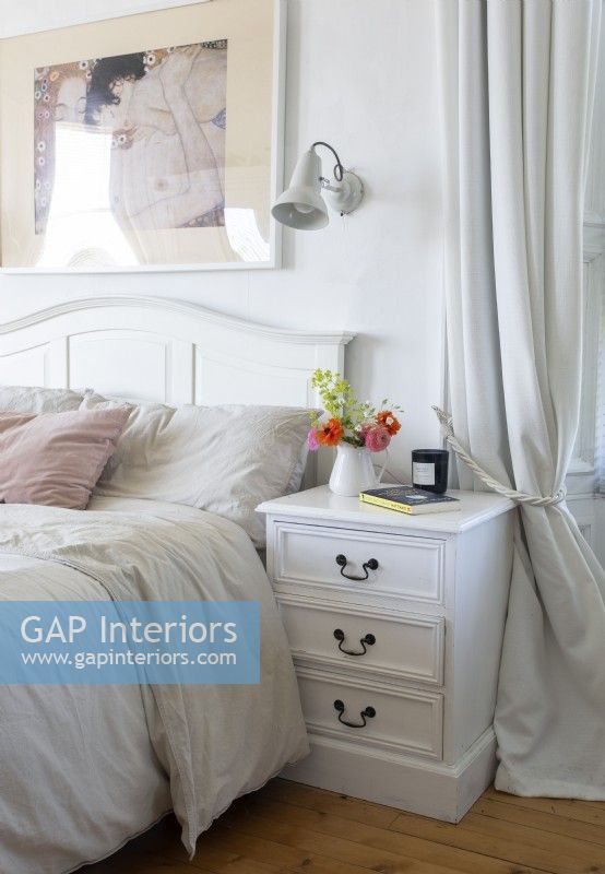 White feminine bedroom - bedside cabinet and flowers