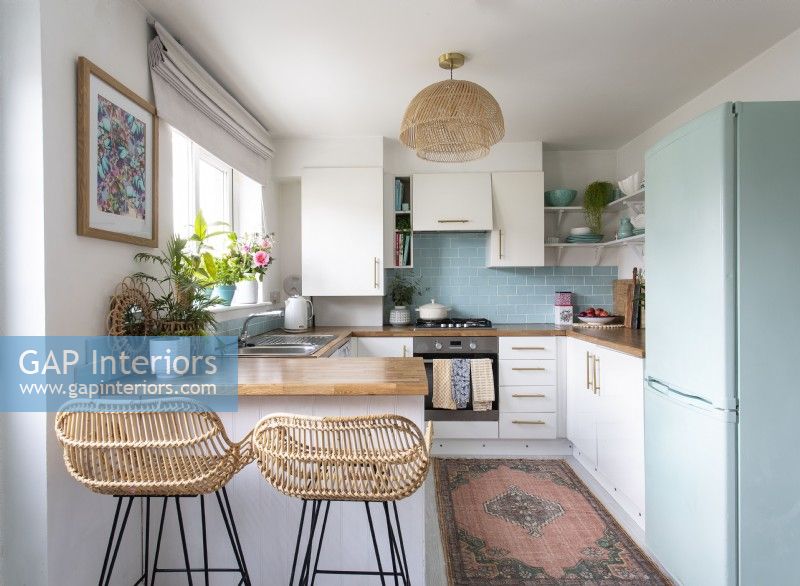 Wicker barstools in small pale blue and white kitchen