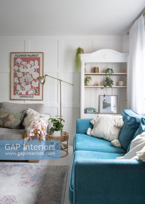 Turquoise sofa and white painted shlelf unit in country living room