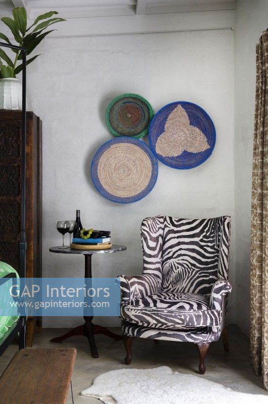 Animal print upholstered armchair and woven basket wall display