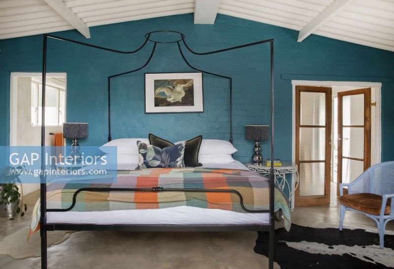 Bedroom with four-poster bed and teal accent wall