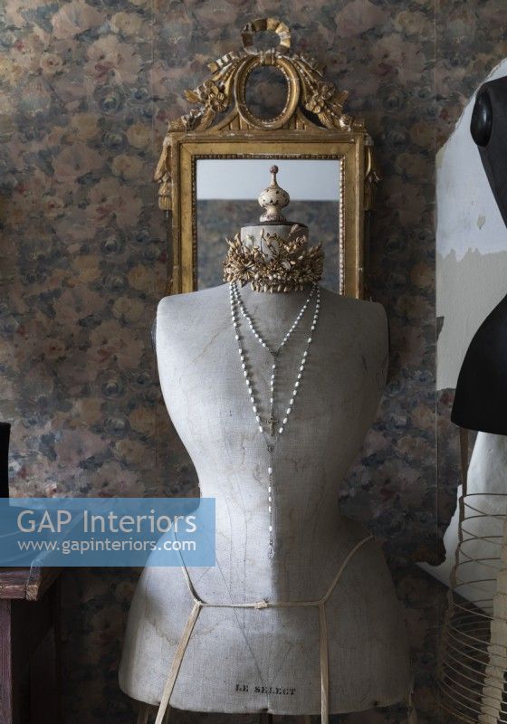 Detail of antique dressmakers mannequin and gilded mirror