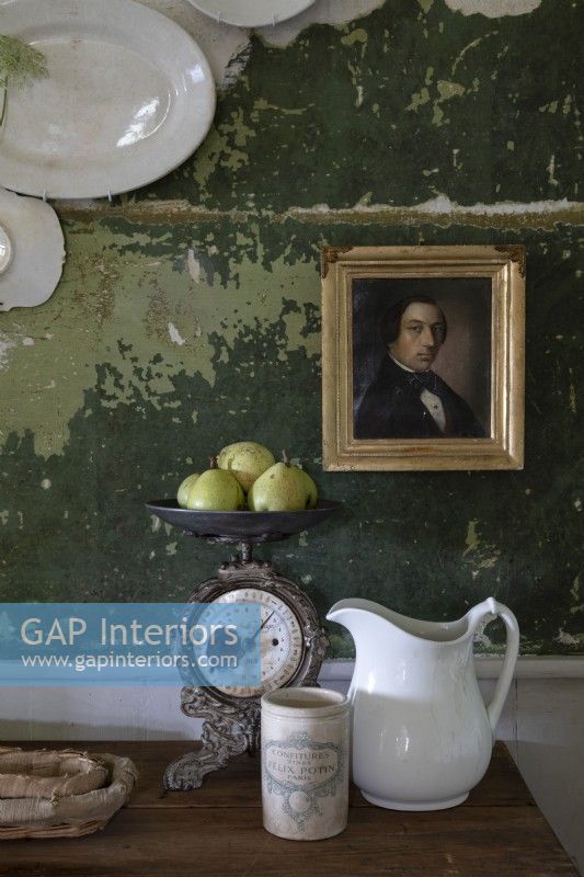 Gilded framed portrait on distressed painted green wall