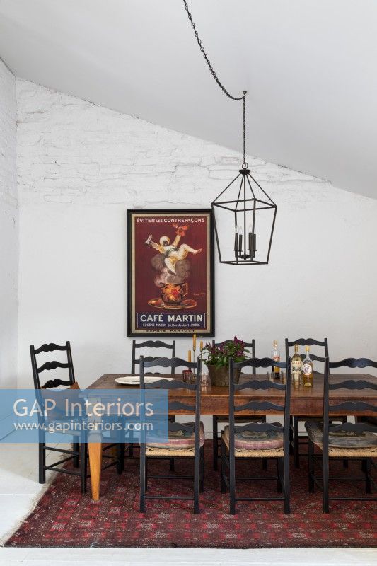 Large framed poster on white wall of country dining room