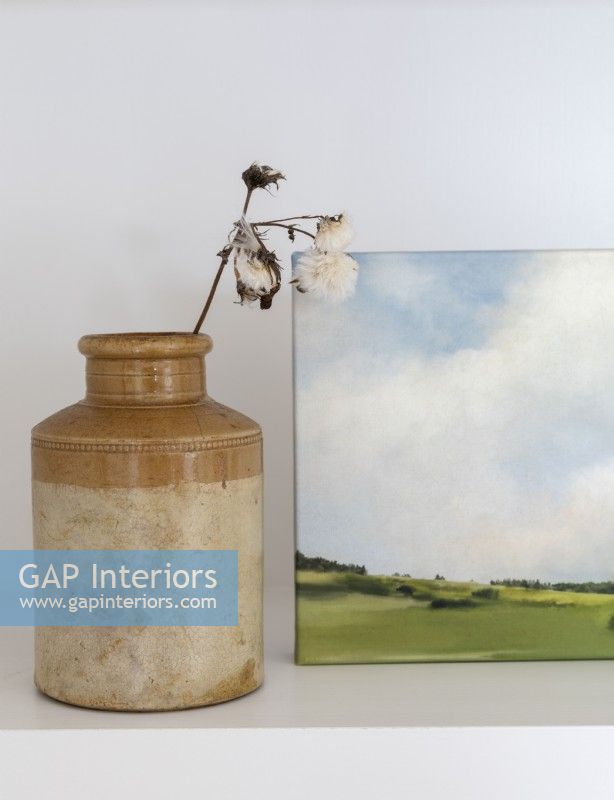 Earthenware pot with dried flowers and landscape painting detail