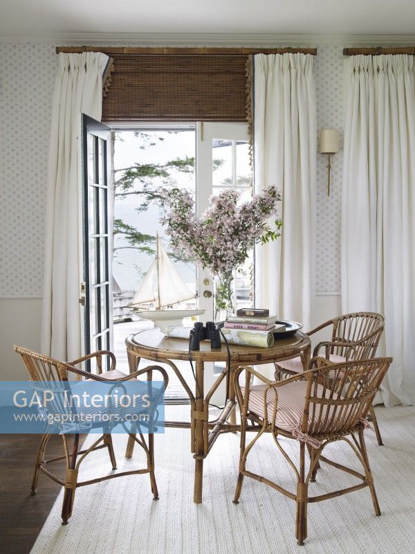 A Maine island living room table vignette with water views and wicker furniture