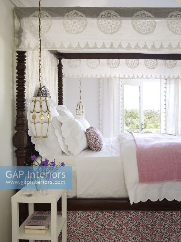 Bedroom with four poster bed and white linens