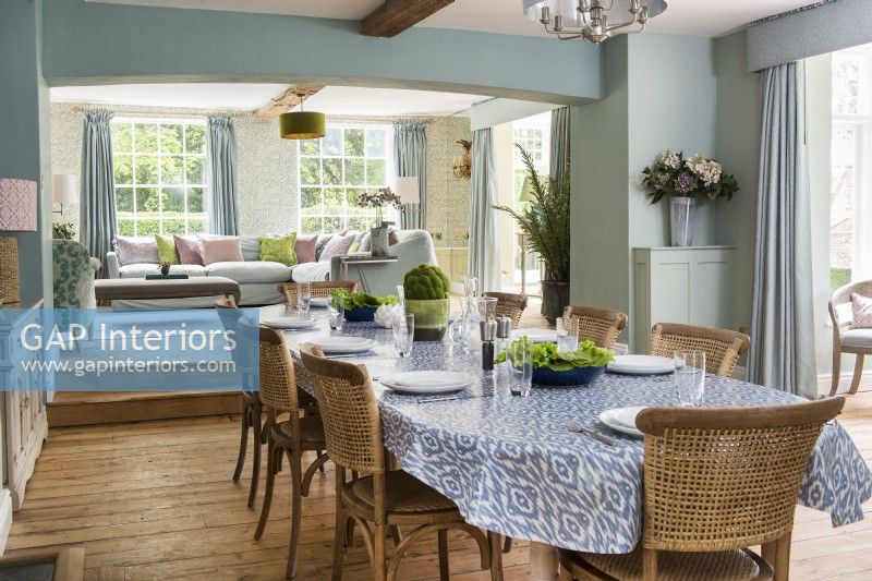 Country dining room laid for meal with view to living room beyond