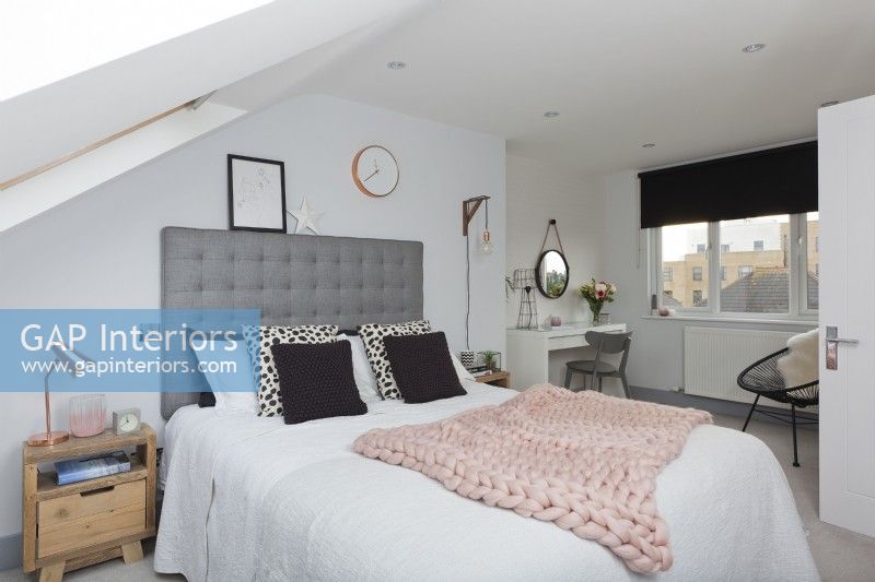Loft bedroom with grey headboard and pink knitted throw