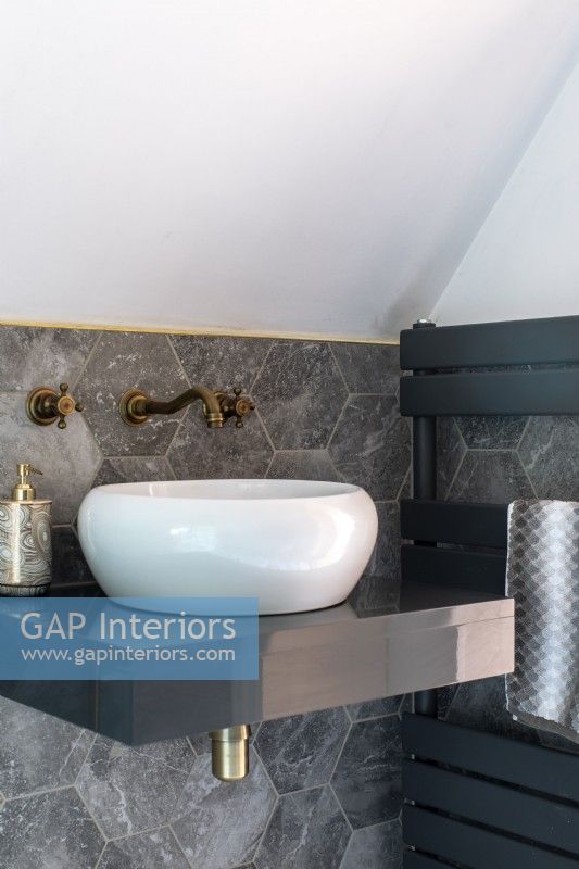 Detail of white sink with grey marble hexagon tiles
