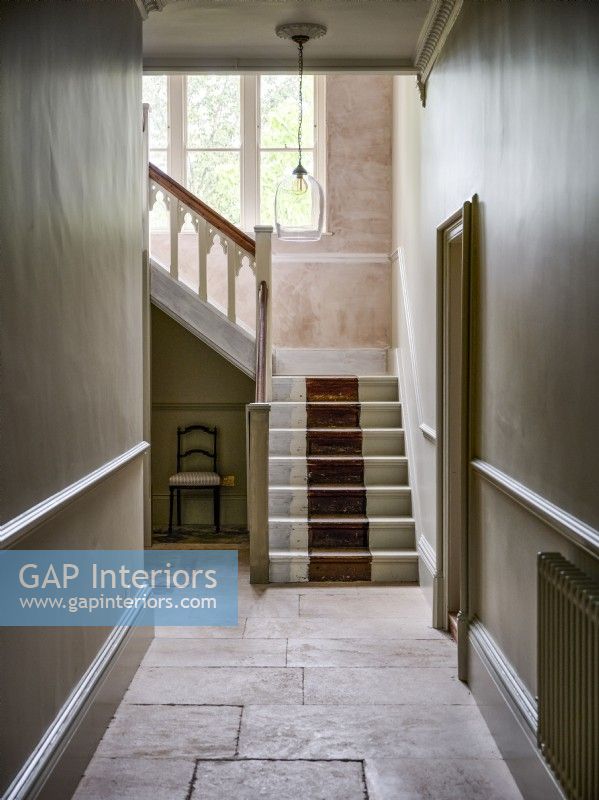 Staircase and hallway with bare plastered walls