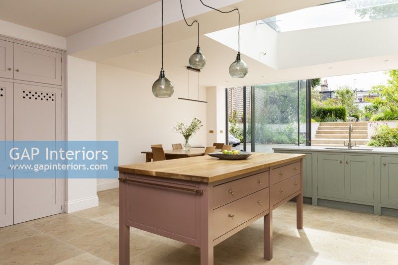 Classic contemporary kitchen with large freestanding pink kitchen island.