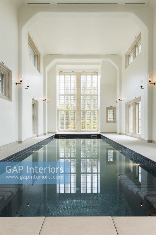 Large indoor swimming pool in a traditional building with floor to ceiling window. 