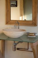 Boonshill Farm, East Sussex. Interior of bathroom with stone basin on glass top. 
