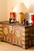 Boonshill Farm, East Sussex. Antique Indian wood and brass dowry chest with lamp and ornamentals.  