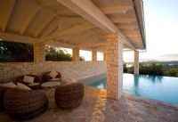 Corfu, Greece: Villa in north east Corfu. Rectangular infinity swimming pool at dawn with wicker seats 