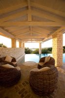 Corfu, Greece: Villa in north east Corfu. Rectangular infinity swimming pool at dawn with wicker seats