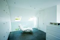 Contemporary white chair in white themed bedroom