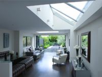 open plan  living and dining room with skylight and patio doors leading out onto contemporary garden designed by Charlotte Rowe
