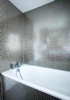 Modern contemporary bathroom with white bath and silver honeycomb effect mosaic tiles