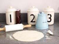 Rolling pin rolling pastry on kitchen worktop